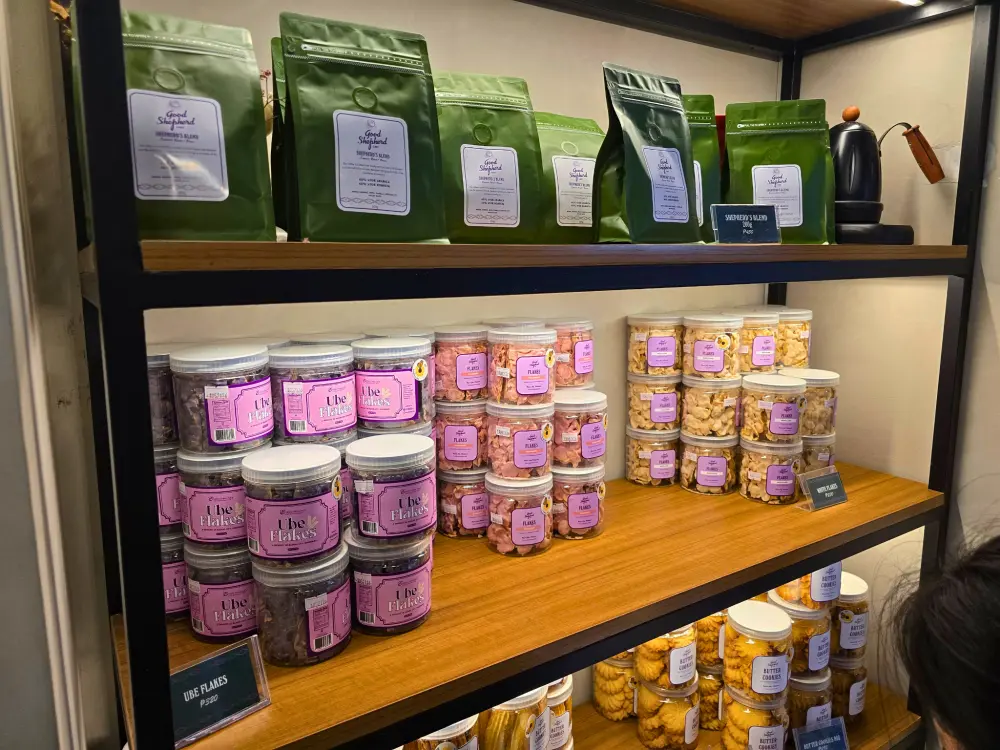 Good Shepherd Caféのオリジナルブレンドコーヒーやウベフレークなどが並ぶお土産用の商品棚