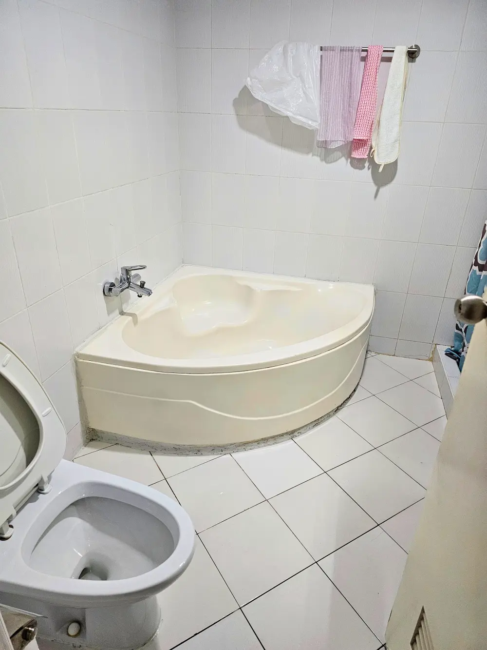 小型のバスタブとトイレが備わった、CBOA内部寮3人部屋のバスルーム
