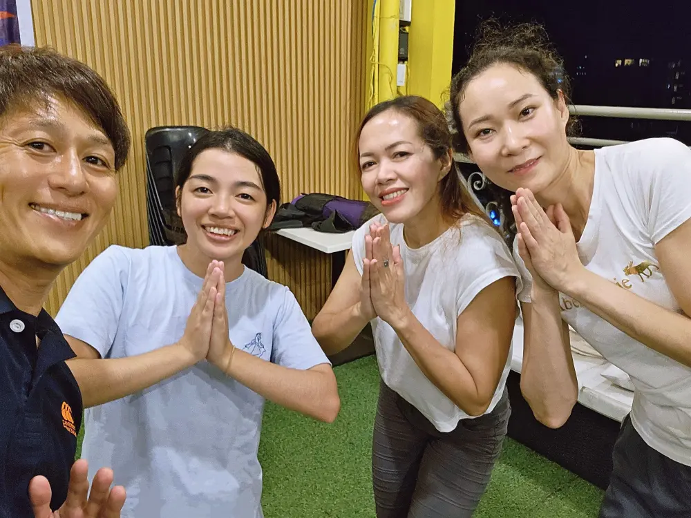 ヨガのポーズをとりながら並ぶ、ヨガコーチのRain先生とモンゴル人学生、Grit留学の2人