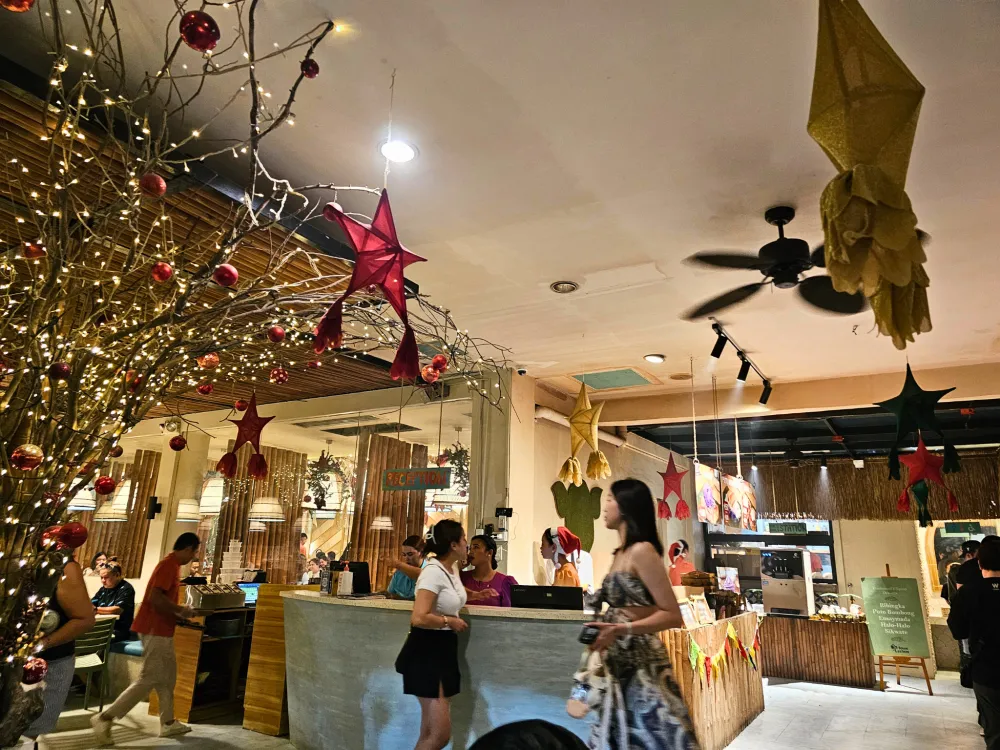 クリスマス装飾の枝やパロルが飾られた、フィリピンのセブ島にあるハウスオブレチョンの店内で行き交うお客さんとスタッフ