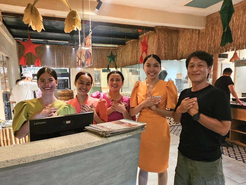 フィリピンのセブ島にあるHouse of Lechonのスタッフ4人とGrit留学の真太郎が、胸に手を当てたポーズで笑顔を見せる記念写真
