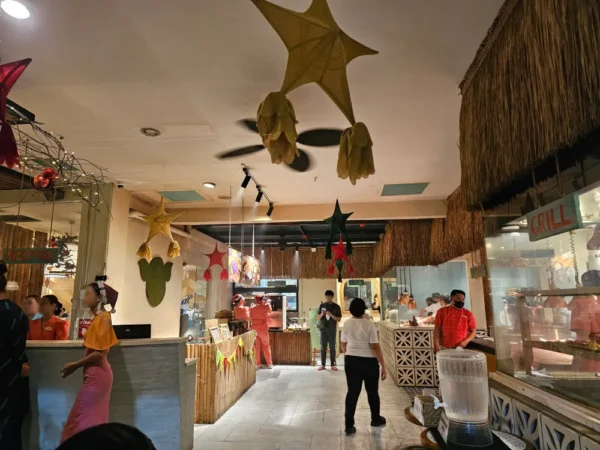 パロルなどのクリスマス装飾が施されたHouse of Lechonの店内と、お客さんに対応するスタッフ