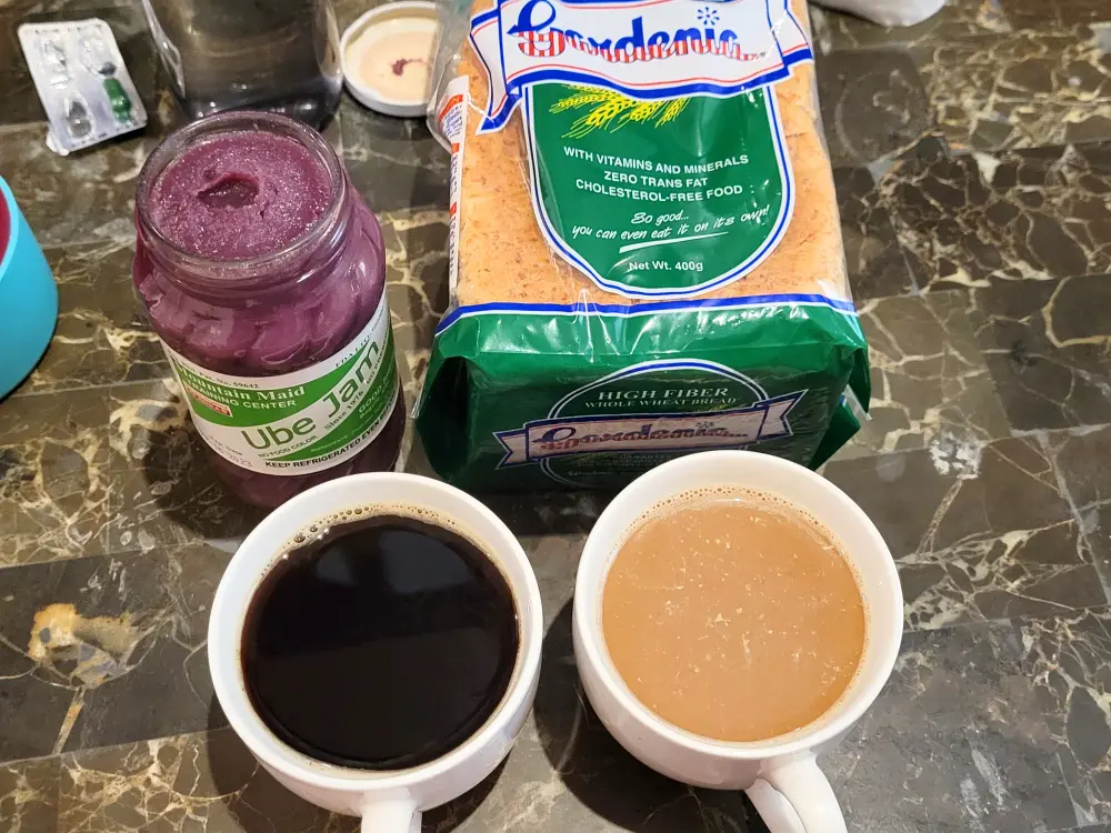 開封したグッドシェパード修道院のウベジャム、Gardeniaの食パン、2杯のコーヒーを並べたテーブル