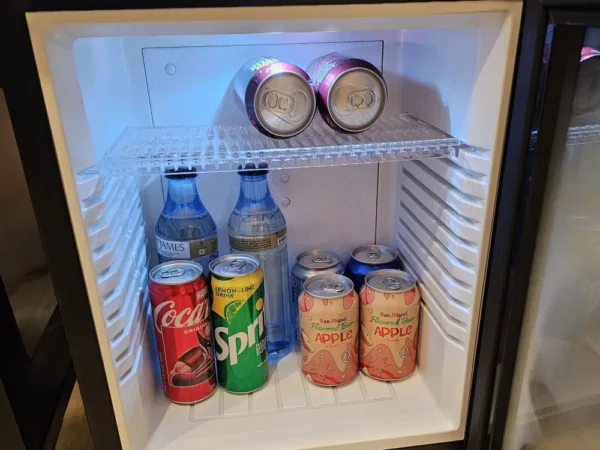 Goldberry Suites & Hotel Cebuのスタジオルームのミニ冷蔵庫に入ったソーダとサンミゲルビール