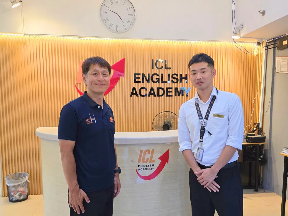 ICL English Academyの受付前で、日本人マネージャーの中野さんと一緒に写真に写るGrit留学の真太郎