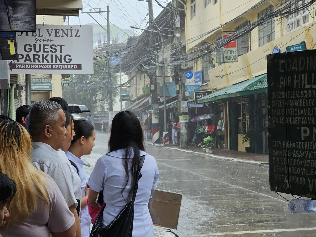 フィリピンのバギオ市のダウンタウンで、大雨の中ジプニーに乗るために列に並ぶ乗客たち