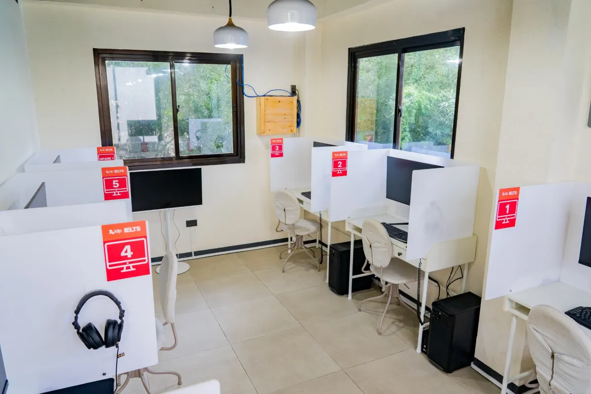 パソコンとヘッドセットを備えたJIC Challenger CampusのIELTS公式コンピューターベース試験会場