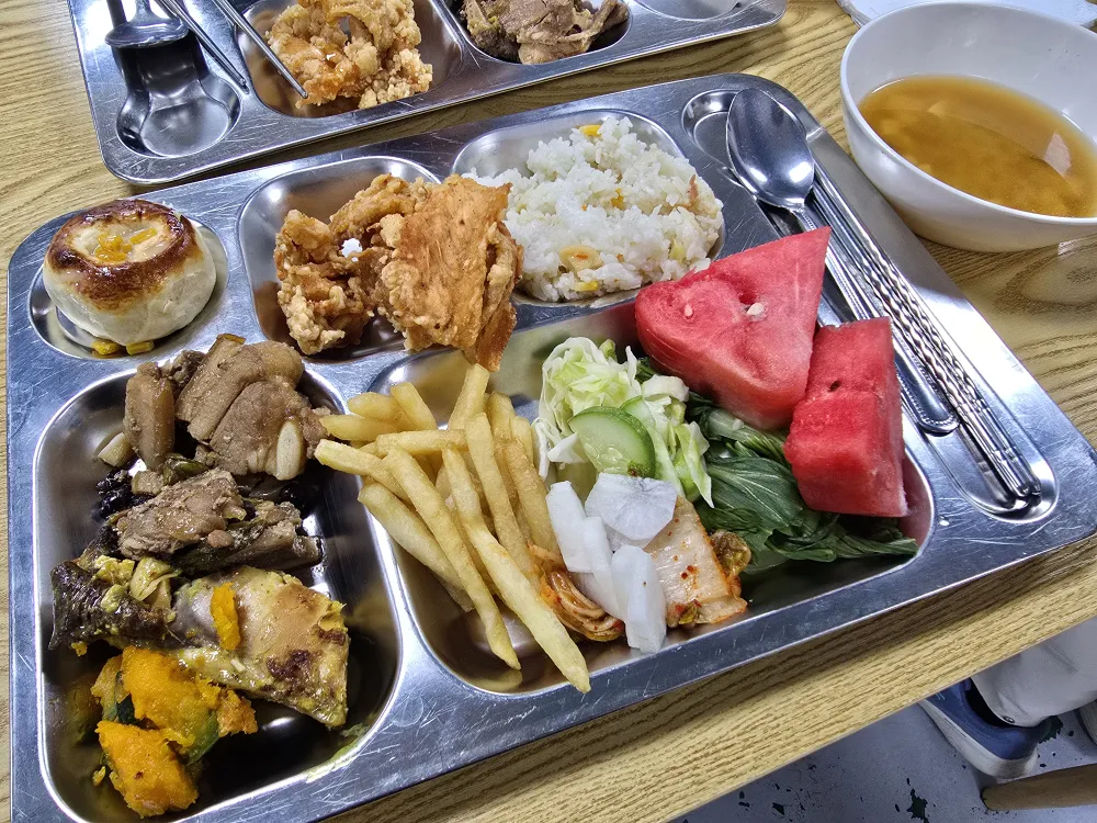 フィリピンのセブ・マクタン島にあるB'Cebuのランチで提供された、肉料理やフライドポテト、野菜、キムチ、スイカ、ご飯、スープなどが並ぶプレート