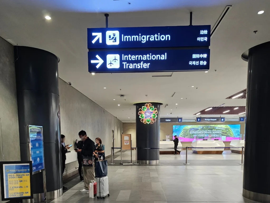 フィリピンのクラーク国際空港（Clark International Airport）で、Immigration（入国審査）とInternational Transfer（国際線乗り継ぎ）の案内看板が掲げられた入国審査手前のエリア