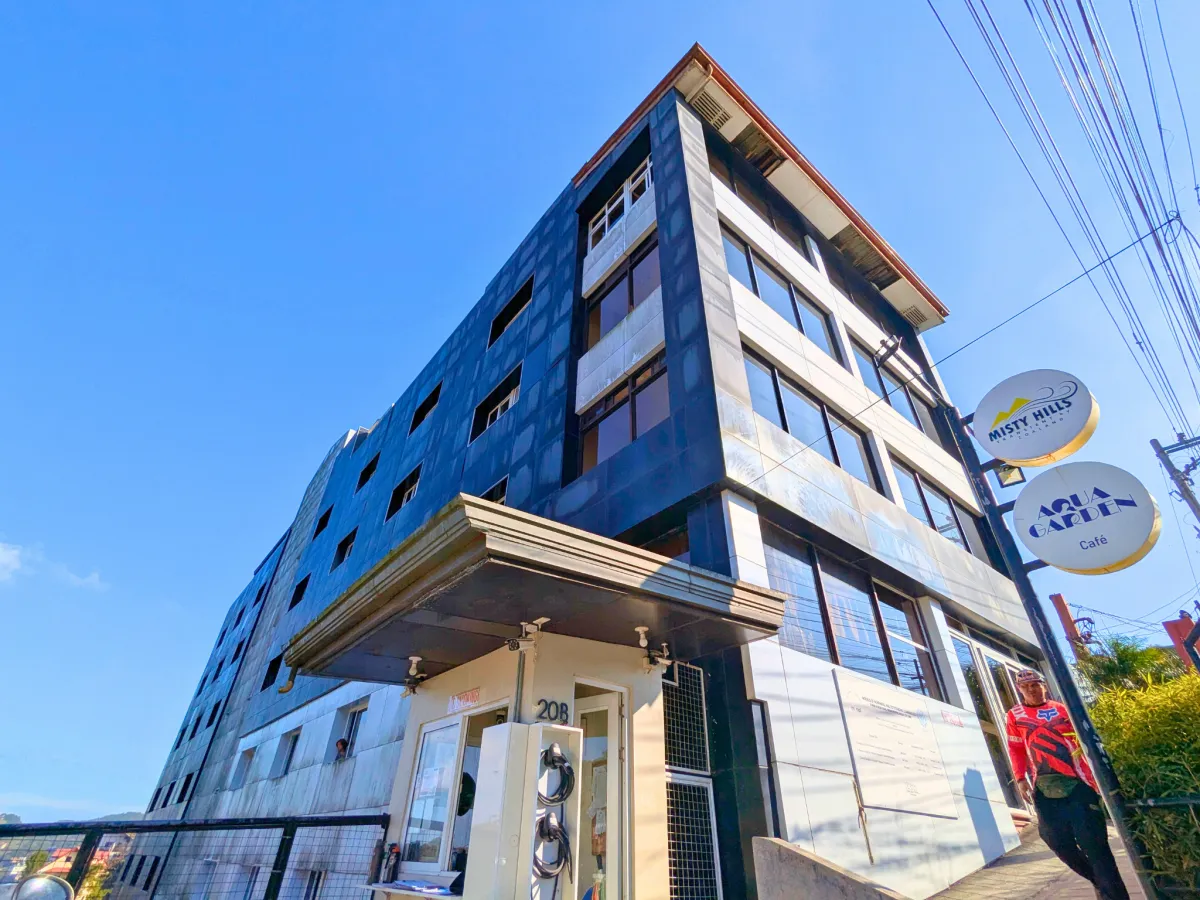 駐車場側から見上げたMONOL Main Campusの校舎外観とAqua Garden Caféの看板