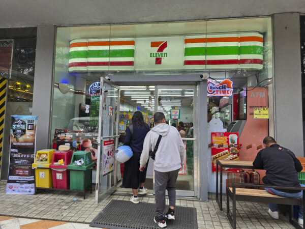 Albergo Hotelにあるセブンイレブンの店舗入口と、店内に入る買い物客