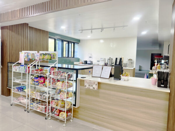カップ麺やお菓子などが並ぶ商品棚と、注文カウンターが設置されたスクールカフェ
