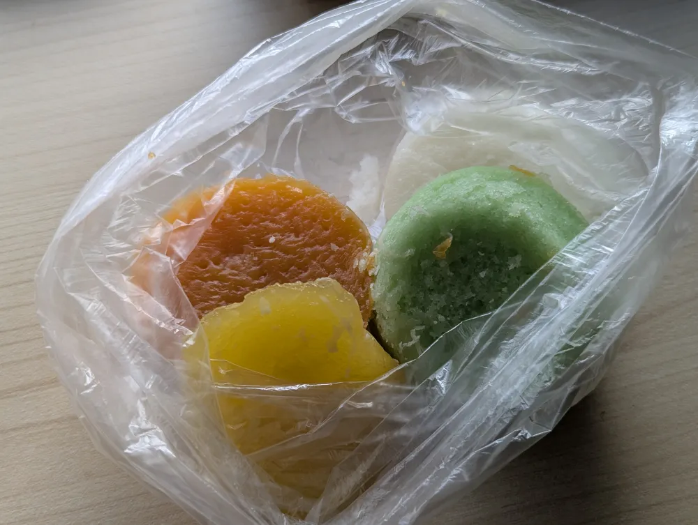 ビニール袋に入ったフィリピンの伝統菓子プトとプト・クチンタ、白色・黄色・緑色・茶色の4種類