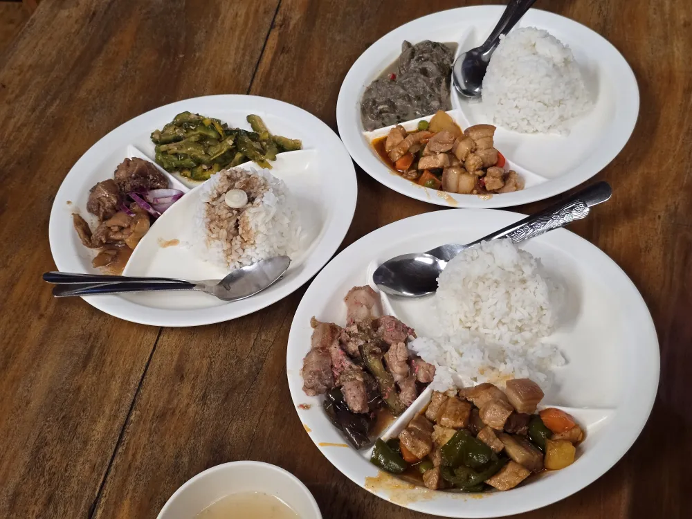 Felomina’s Restaurantで注文した3人分の昼食、ご飯と肉料理や野菜料理を盛り付けた3枚のプレート、シニガンスープ
