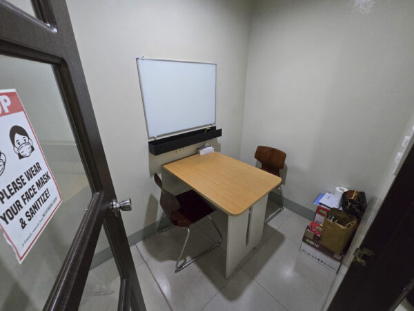 机と向かい合う2脚の椅子、壁掛けホワイトボードが設置されたPines IELTS Specialized Campusのマンツーマンクラス用教室