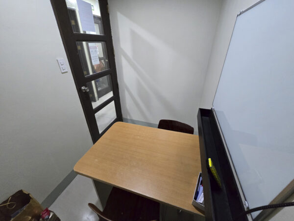講師席側から入口方向を見た、机と椅子、ホワイトボードがある校舎4階のマンツーマンクラス用教室