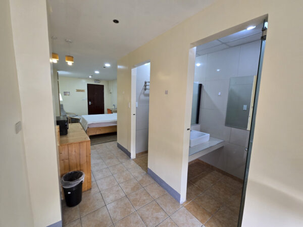シャワールームとトイレが独立して設けられ、奥にベッドエリアがある1人部屋Aの室内