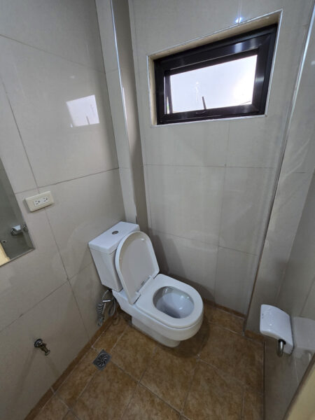 小窓とハンドビデ、トイレットペーパーホルダーが設置された1人部屋Aの独立したトイレ